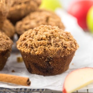 apple cinnamon muffins with crumble topping on parchment paper